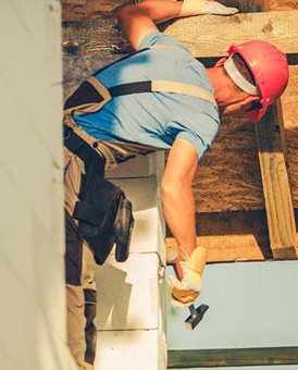 A contractor is working on construction with a hammer in his hand